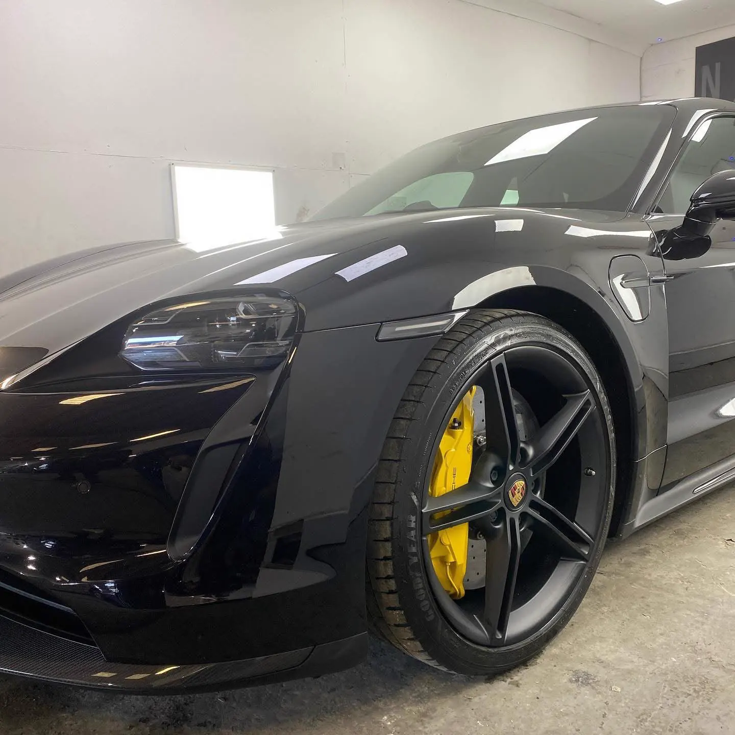 Porsche Taycan with yellow brake calipers and satin black wheels