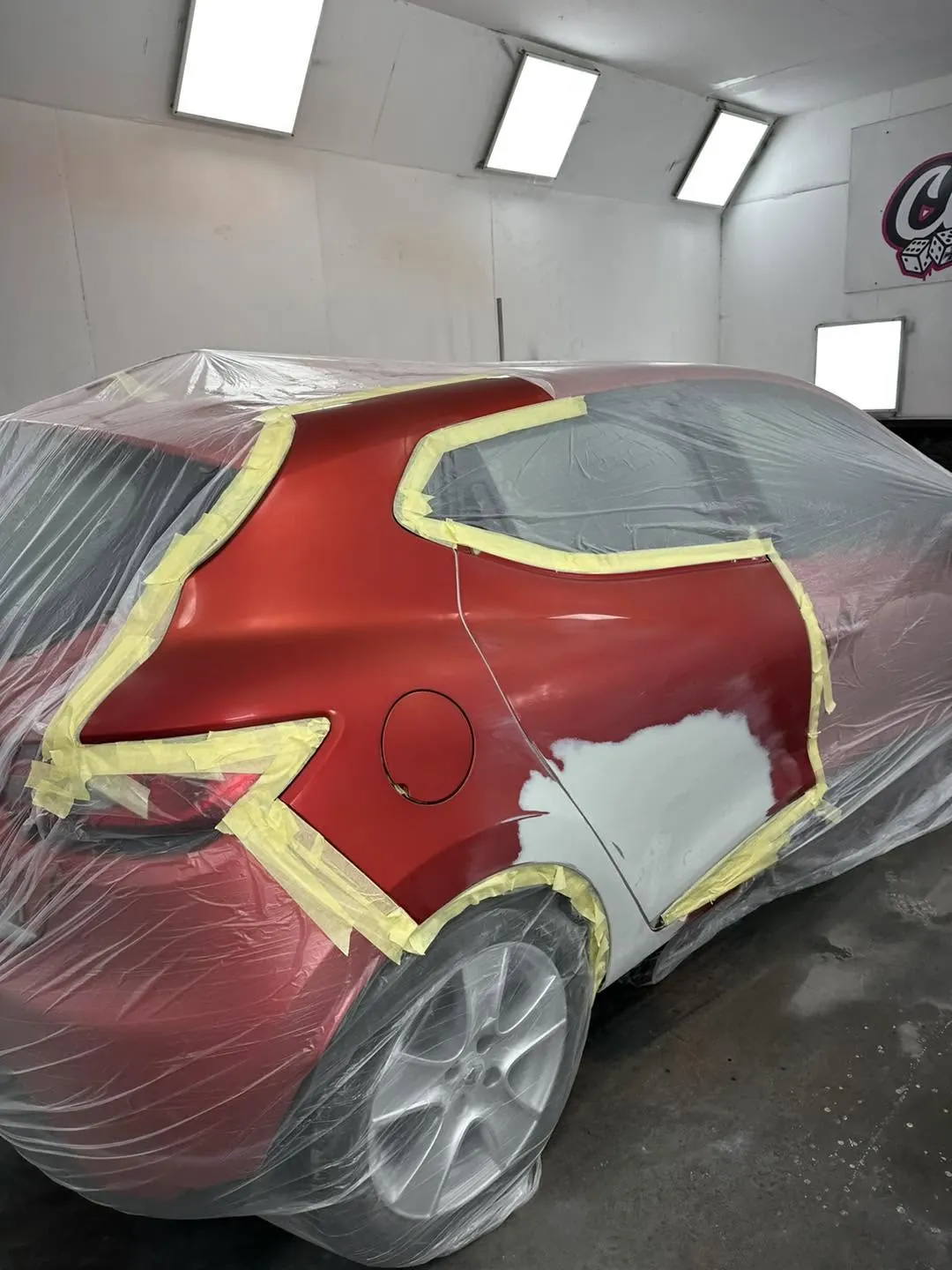 Red vehicle panel undergoing body repair and preparation